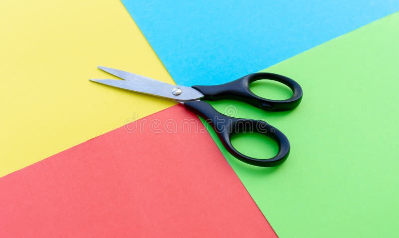 Scissors placed on colored papers stock photography