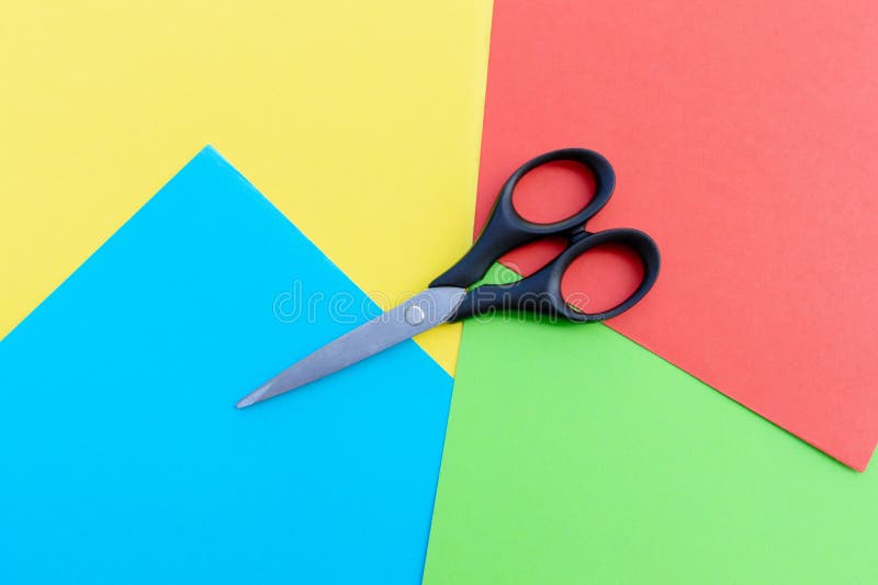 Scissors placed on colored papers royalty free stock image