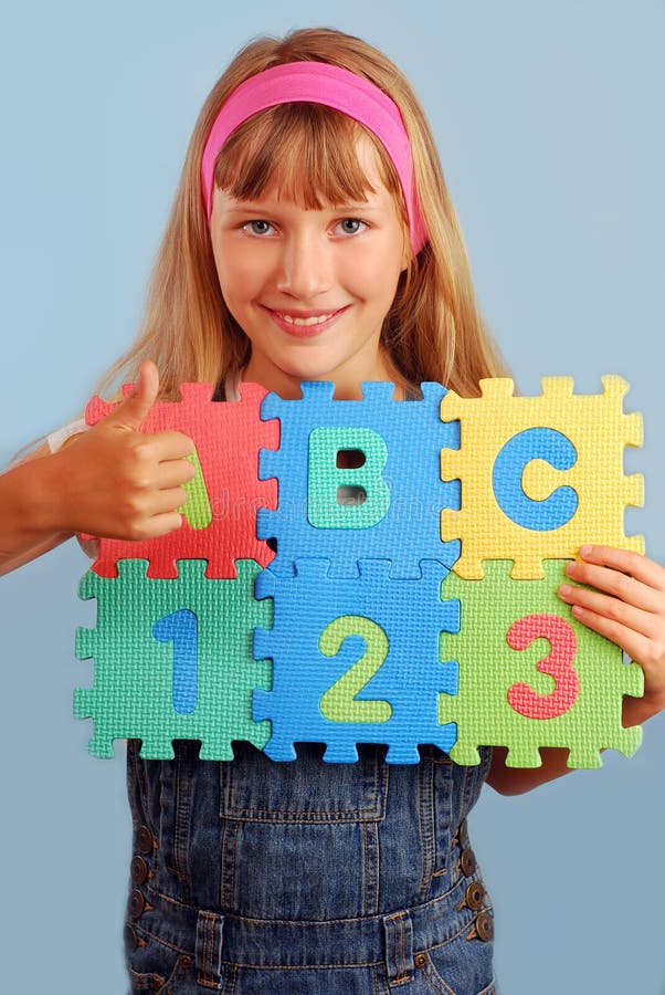 Scolara con il puzzle di alfabeto fotografia stock