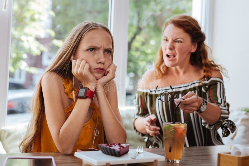 Scolara favorita che ritiene discussione arrabbiata con la madre fotografie stock libere da diritti Scolara favorita che ritiene discussione arrabbiata con la madre fotografie stock libere da diritti