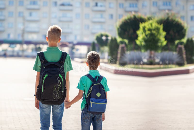 Scolari con andare a scuola degli zainhi Bambini e istruzione nella città fotografie stock Scolari con andare a scuola degli zainhi Bambini e istruzione nella città fotografie stock