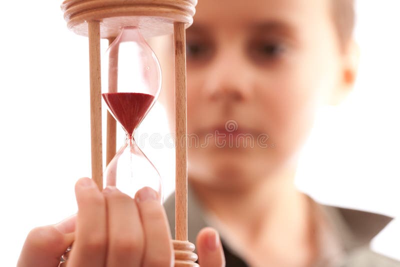 Scolaro che tiene una clessidra fotografia stock libera da diritti Scolaro che tiene una clessidra fotografia stock libera da diritti