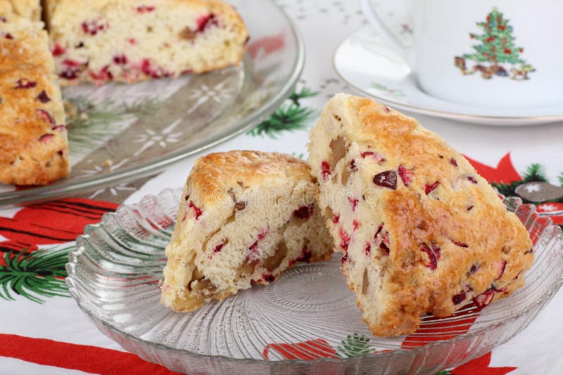 Two cranberry nut scones on a Christmas tablecloth. Two cranberry nut scones on a Christmas tablecloth