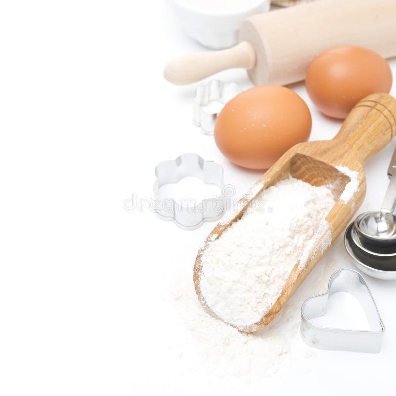 Scoop with wheat flour, rolling pin, eggs and cookie cutters isolated on white. Scoop with wheat flour, rolling pin, eggs and cookie cutters isolated on white