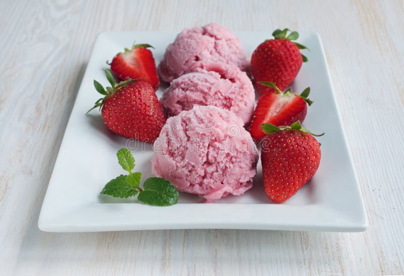 Scoops of Delicious Strawberry Ice Cream with Mint and Fresh Berries on