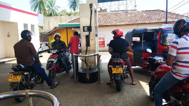 Scooters are refueled at a gas station in Sri Lanka.