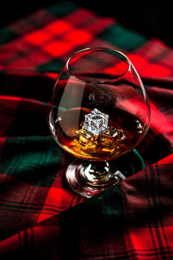 Scottish whiskey in a glass  on tartan background