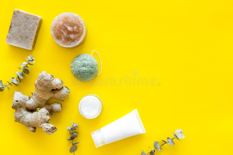 Scrabs et écrème pour l'ensemble cosmétique naturel avec les herbes et le gingembre sur la moquerie jaune de vue supérieure de fo photo libre de droits