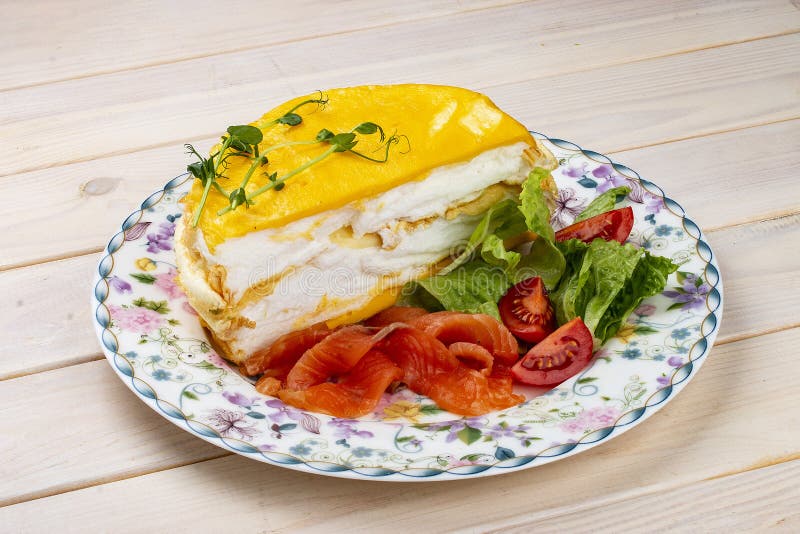 Scrambled Eggs Layered with Salmon and Fresh Vegetables. Breakfast