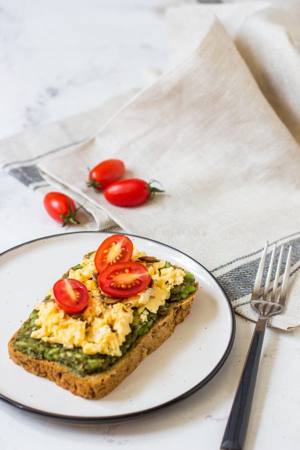 Scrambled Eggs on Whole Wheat Bread with Avocado and Cherry Tomatoes