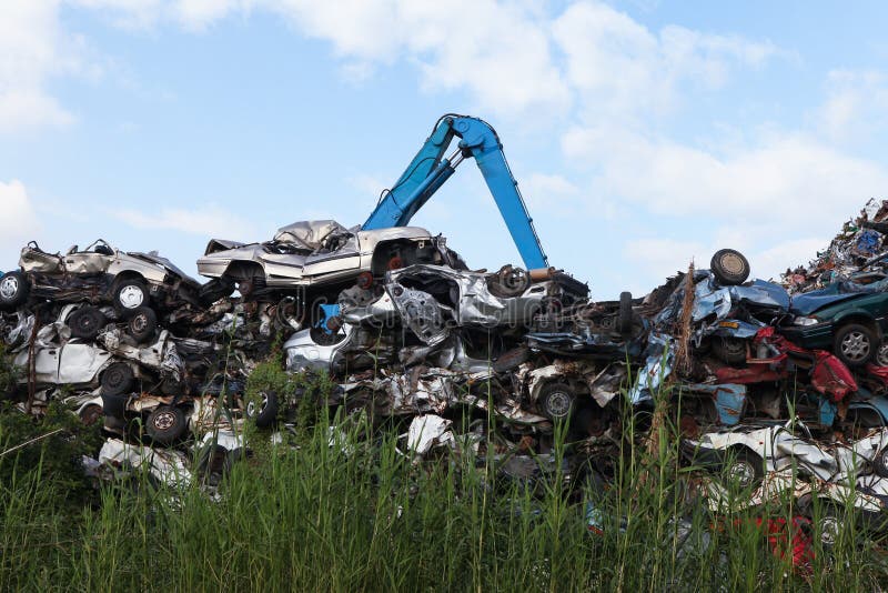 Scrap yard with crushed cars and blue sky