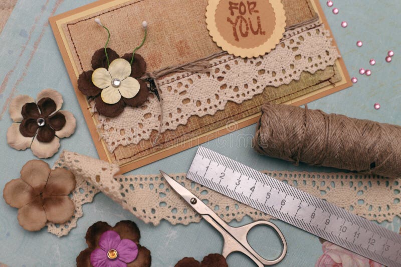 Hand made scrapbooking post card and tools lying on a table