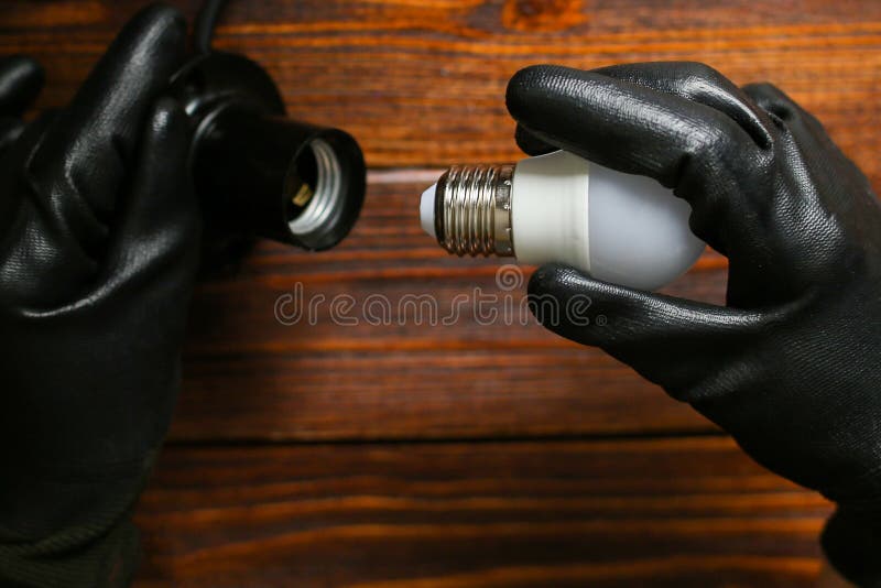 Screw the light bulb into the lamp socket. stock photos
