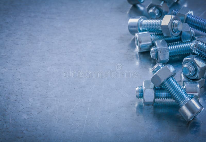 Screwbolts and nuts on scratched metallic background constructio
