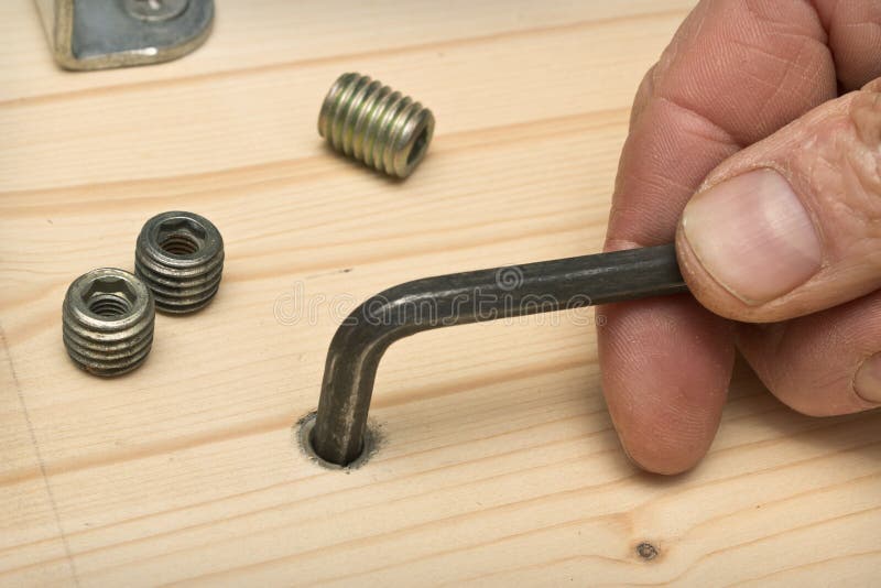 Screwing Furniture Fasteners In A Wooden Shield Royalty Free Stock