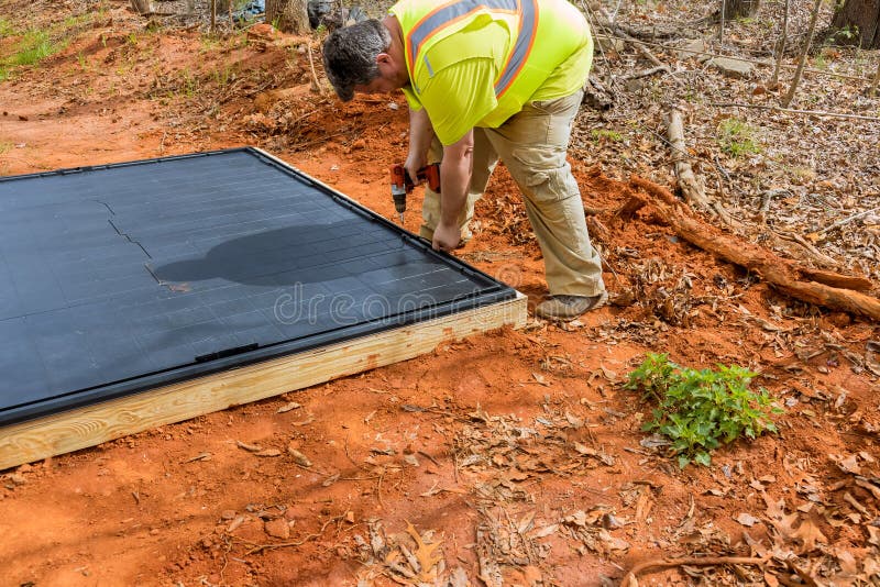 Screwing the plastic base platform for plastic vinyl storage shed royalty free stock image
