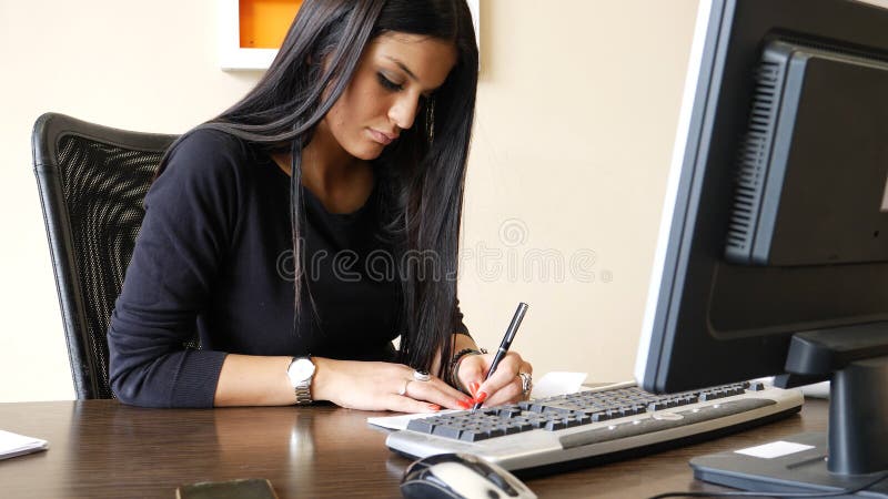 Scrittura femminile dell'impiegato di concetto e controllo di firma fotografia stock Scrittura femminile dell'impiegato di concetto e controllo di firma fotografia stock