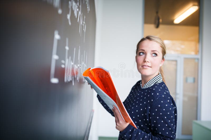 Scrittura graziosa e giovane dello studente di college sulla lavagna/blackboa fotografia stock libera da diritti Scrittura graziosa e giovane dello studente di college sulla lavagna/blackboa fotografia stock libera da diritti