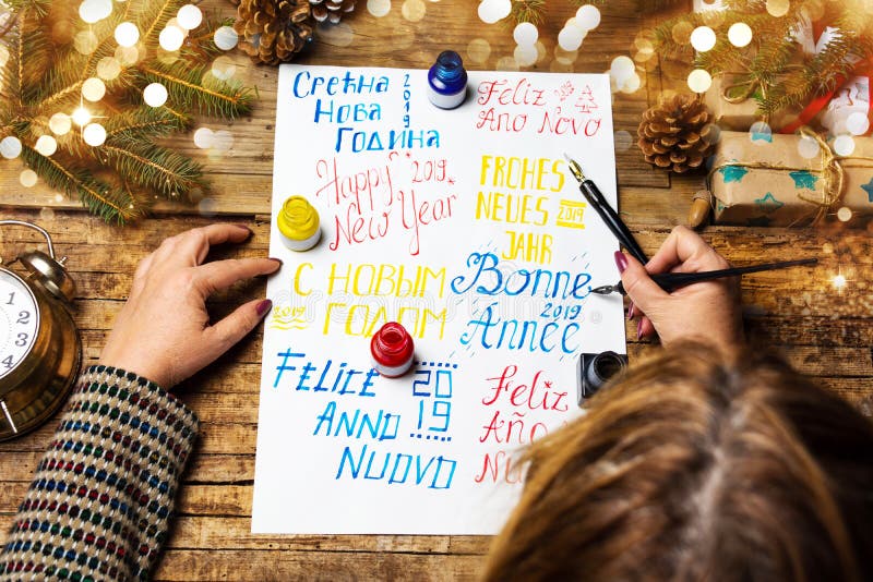 Scrivendo una carta del buon anno in varie lingue fotografie stock Scrivendo una carta del buon anno in varie lingue fotografie stock