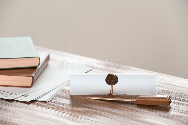 Scroll with notary seal, books, documents and letter opener on wooden table stock images Scroll with notary seal, books, documents and letter opener on wooden table stock images
