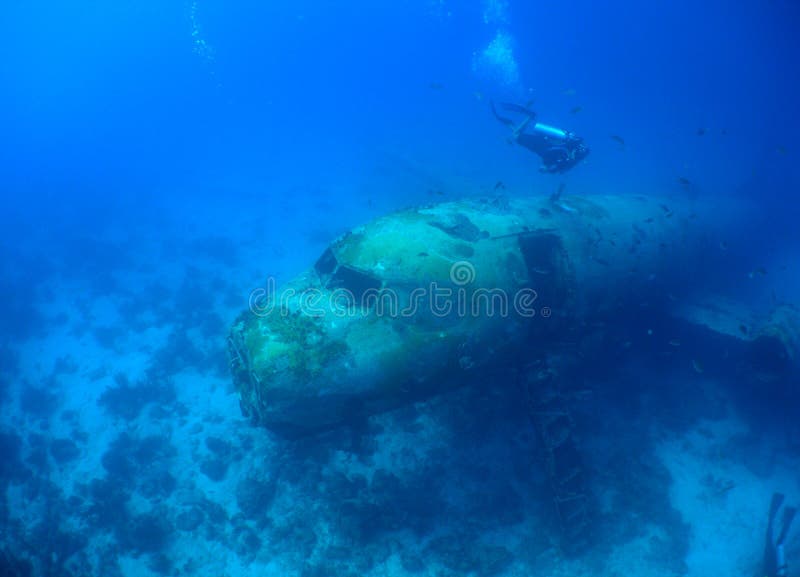 Scuba diver swimming around a sunken plane