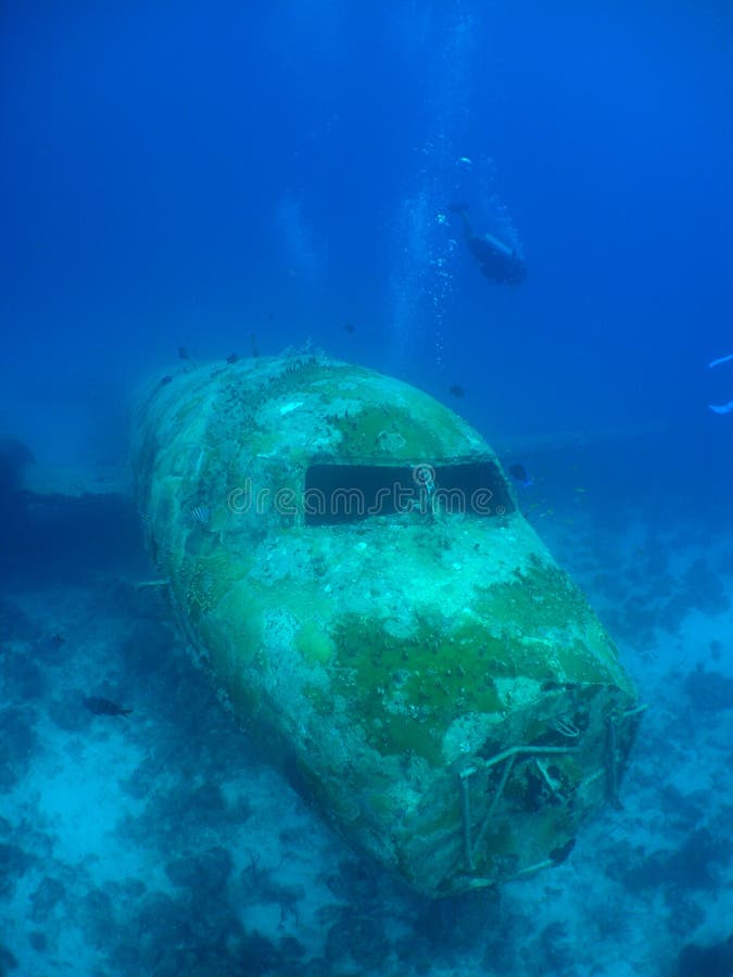 Scuba diver swimming around a sunken plane