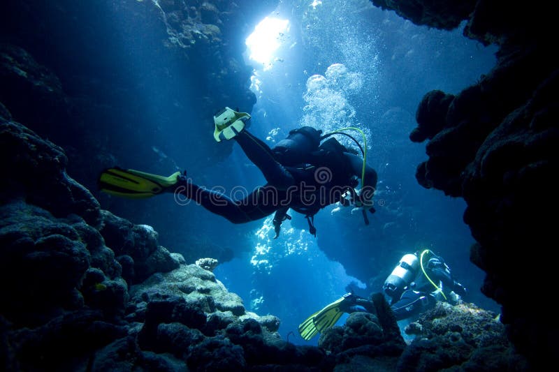 Scubadykare i undervattens- grotta