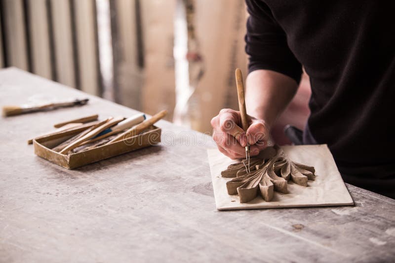 The sculptor creates a bas-relief. Plaster workshop. Close up. Selective focus stock photography