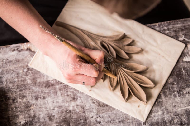 The sculptor creates a bas-relief. Plaster workshop. Close up. Selective focus stock images