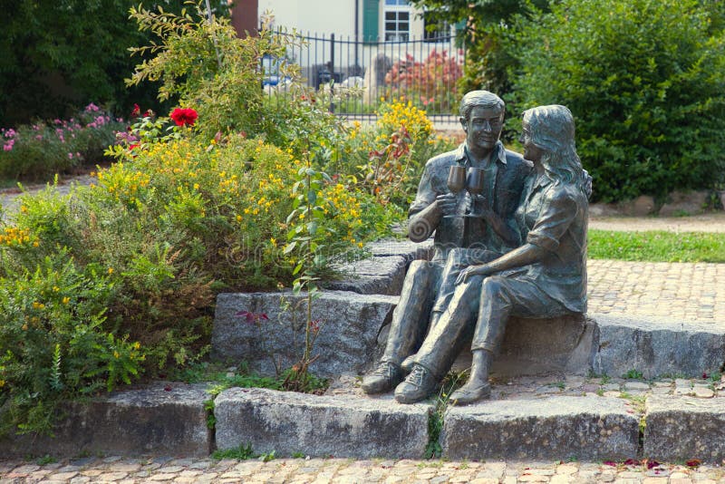 A sculpture in the castle park shows a couple sitting down on the stone steps and toasting each other. royalty free stock photography A sculpture in the castle park shows a couple sitting down on the stone steps and toasting each other. royalty free stock photography