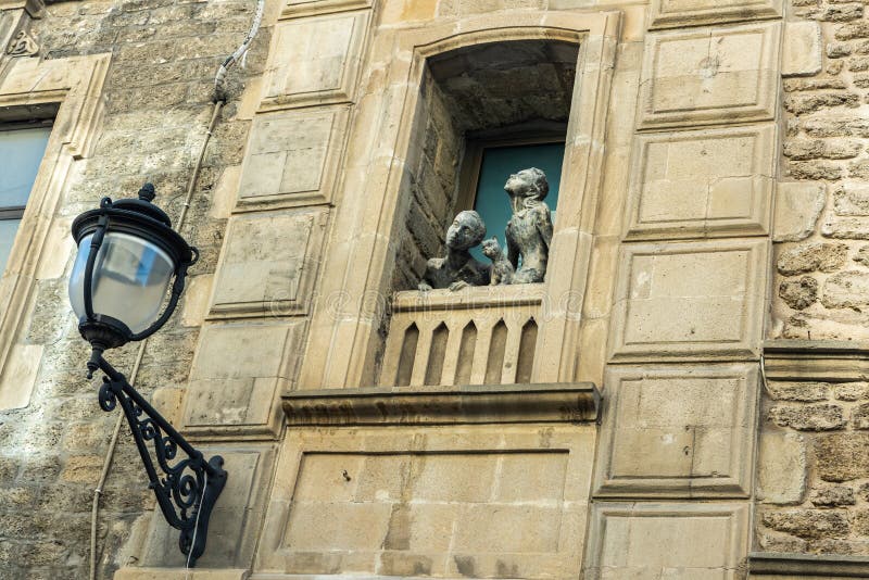 Sculpture d'une fille, d'un garçon et d'un chat regardant par une fenêtre sur la rue Basheni dans la vieille ville de Bakou photographie stock Sculpture d'une fille, d'un garçon et d'un chat regardant par une fenêtre sur la rue Basheni dans la vieille ville de Bakou photographie stock