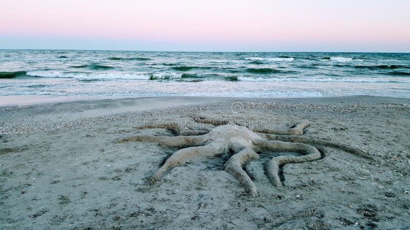 Octopus in sand sculpture on Vadu Beach in Black Sea, Romania at sunset. Octopus in sand sculpture on Vadu Beach in Black Sea, Romania at sunset.