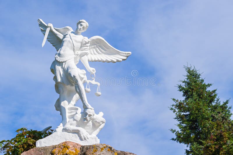 Sculpture of St. Michael the Archangel with sword and libra striking devil