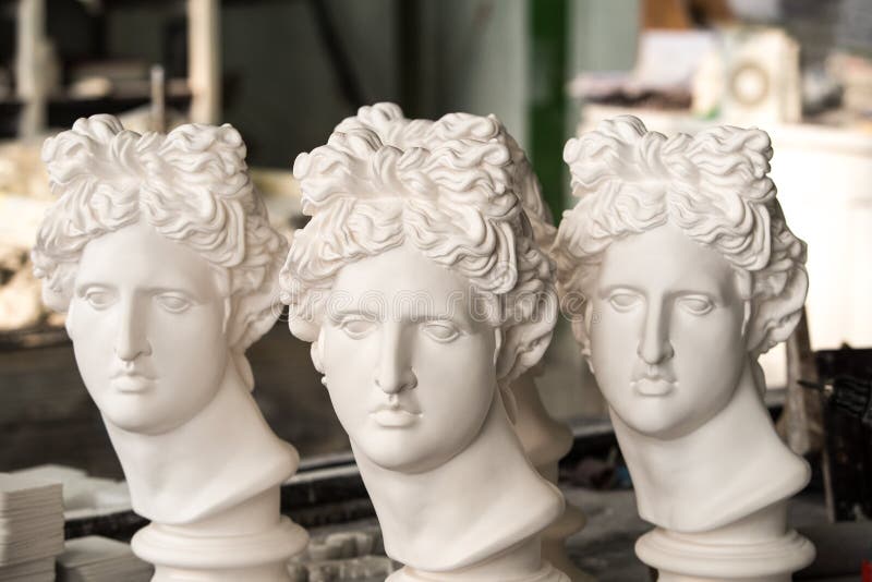 Sculptures en gypse Les têtes du gypse Apollo dans l'atelier photographie stock Sculptures en gypse Les têtes du gypse Apollo dans l'atelier photographie stock