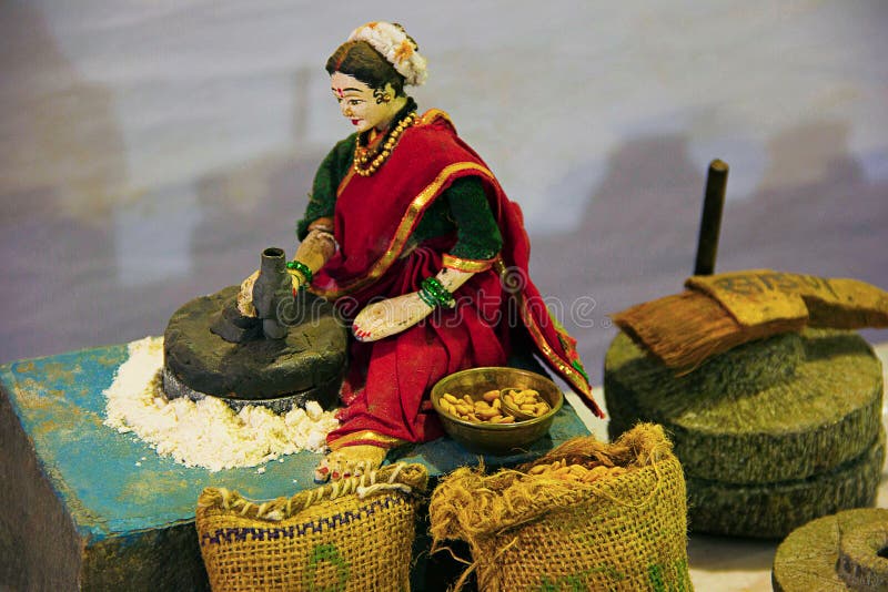 Scultura dei grani tradizionali del grano della macinazione della donna di Maharashtrian fotografie stock libere da diritti Scultura dei grani tradizionali del grano della macinazione della donna di Maharashtrian fotografie stock libere da diritti