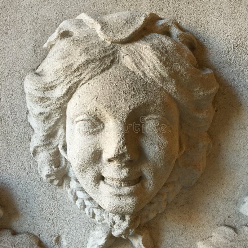 Scultura del bambino di sorriso sulla parete immagine stock