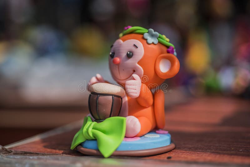 Scultura di argilla della scimmia rosso arancio che tamburella piccolo giocattolo fotografia stock Scultura di argilla della scimmia rosso arancio che tamburella piccolo giocattolo fotografia stock