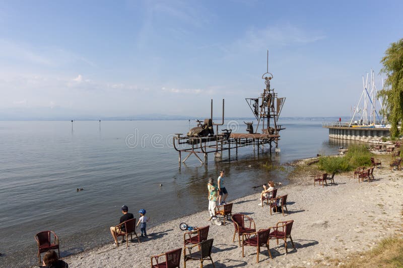 FRIEDRIEHSHAFEN, GERMANY - JUNE 4, 2023: Sculpture on Lake Constance Klangschiff Im Augenblick, people and chairs on the shore for viewing. FRIEDRIEHSHAFEN, GERMANY - JUNE 4, 2023: Sculpture on Lake Constance Klangschiff Im Augenblick, people and chairs on the shore for viewing
