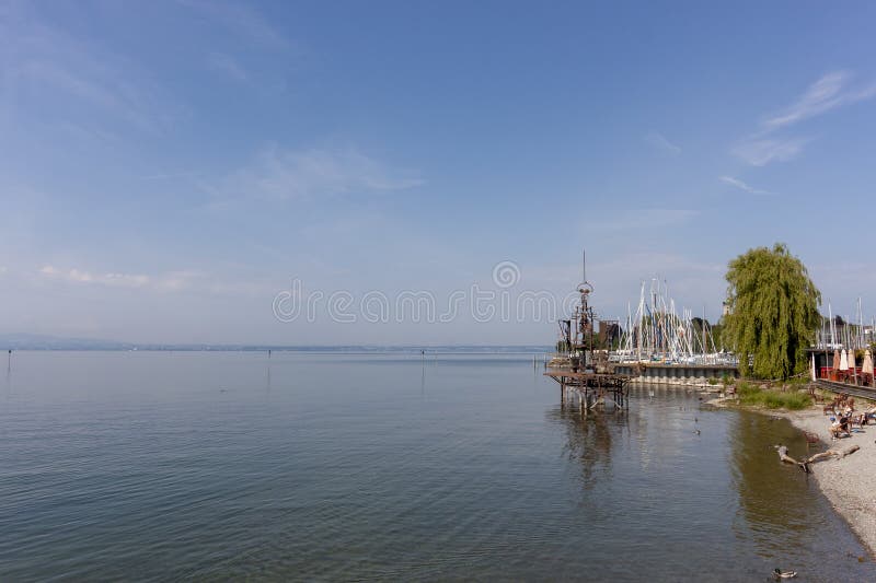 FRIEDRIСHSHAFEN, GERMANY - JUNE 4, 2023: Sculpture on Lake Constance Klangschiff Im Augenblick, people and chairs on the shore for viewing. FRIEDRIСHSHAFEN, GERMANY - JUNE 4, 2023: Sculpture on Lake Constance Klangschiff Im Augenblick, people and chairs on the shore for viewing