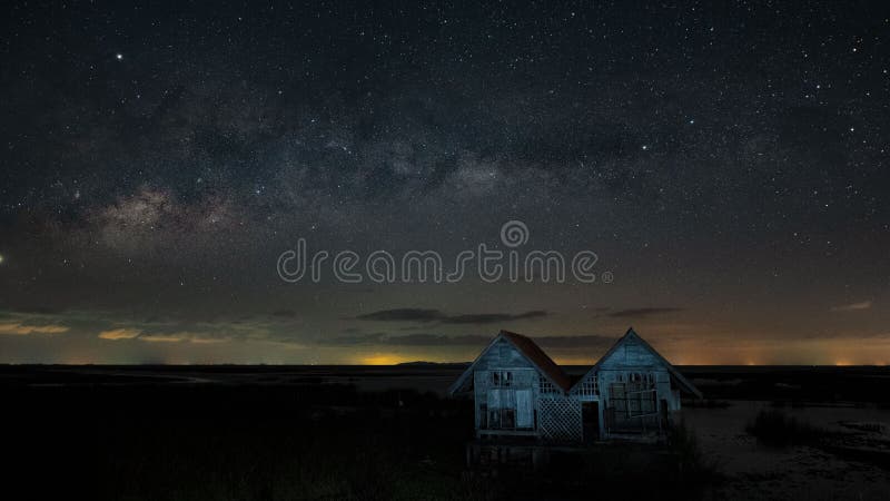 Scène de galaxie milkyway au ciel et à l'arrière-plan de deux vieilles maisons en bois u photo libre de droits Scène de galaxie milkyway au ciel et à l'arrière-plan de deux vieilles maisons en bois u photo libre de droits