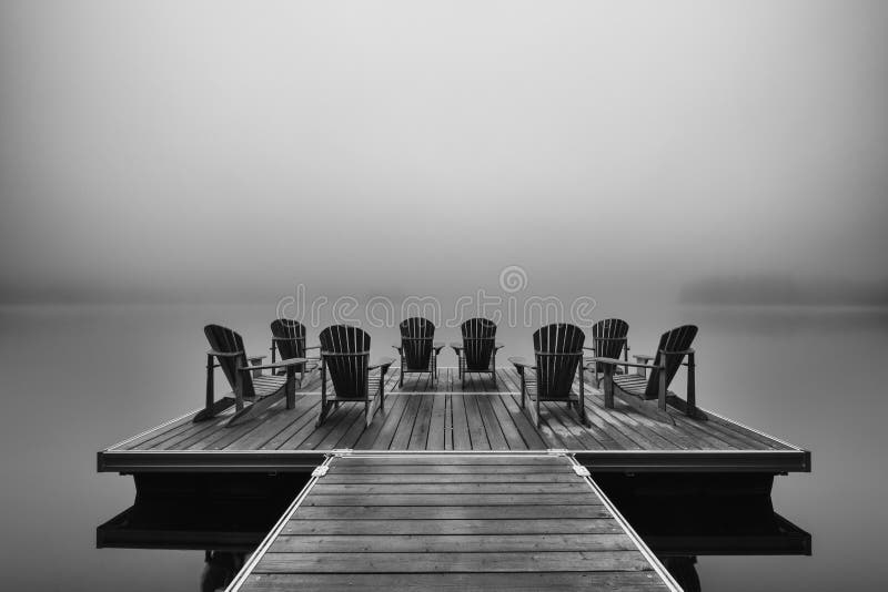 Sdrai di Adirondack sul bacino del lago fotografia stock libera da diritti Sdrai di Adirondack sul bacino del lago fotografia stock libera da diritti