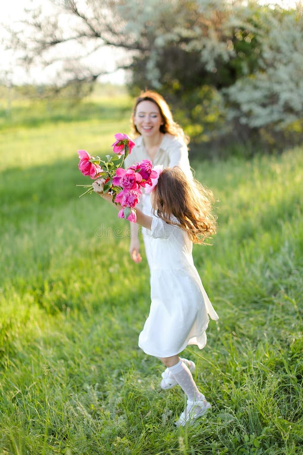 Se concentrer sur la petite fille tenant la main de la mère et garder le bouquet de fleurs. images libres de droits