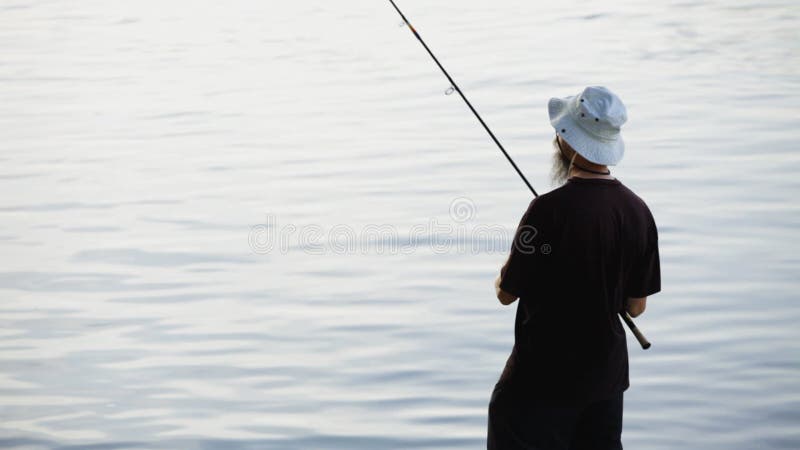 Se divierte la pesca del pescador en el río, usando señuelos de la pesca