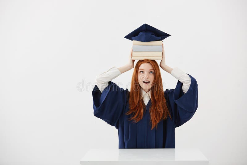 Se tenir licencié étonné de fille réserve sur la tête sous le chapeau au-dessus du fond blanc Copiez l'espace photos libres de droits Se tenir licencié étonné de fille réserve sur la tête sous le chapeau au-dessus du fond blanc Copiez l'espace photos libres de droits