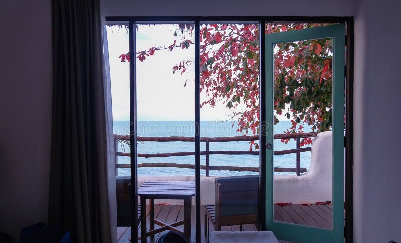 Sea facing beach resort room; view of balcony through large open windows