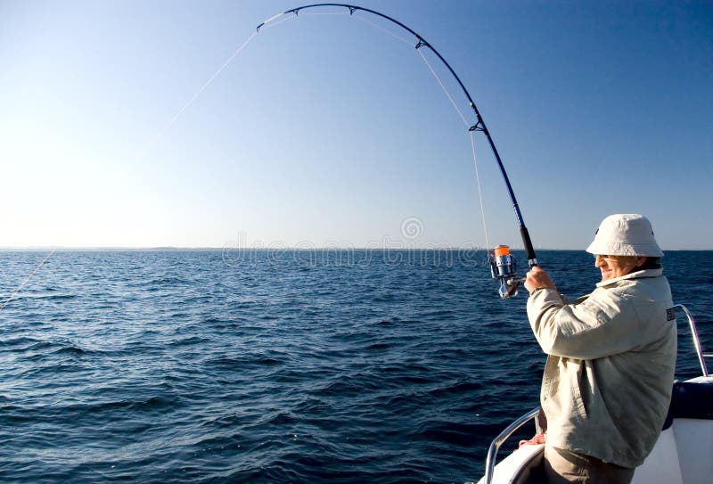 Un uomo con una canna da pesca, tirando la sua linea dura.