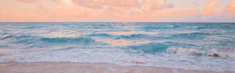 Sea ocean beach sunset sunrise landscape outdoor. Water wave with white foam. Beautiful sunset airy pink yellow sky with clouds.