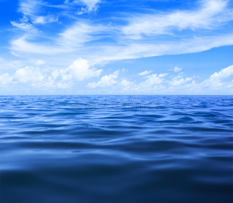Mare o oceano, superficie dell'acqua con un cielo blu e nuvole.