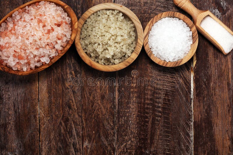 Sea Salt in Bowl. Crystals of Salt on Table and Himalayan Salt Stock