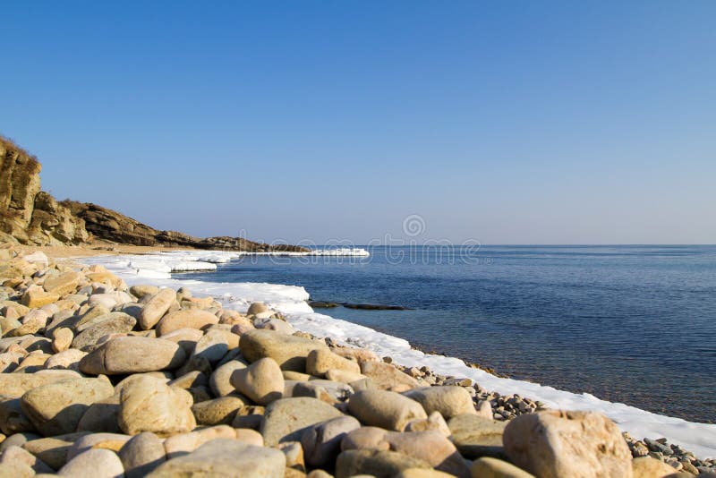 Sea stones on the beach, winter ice.